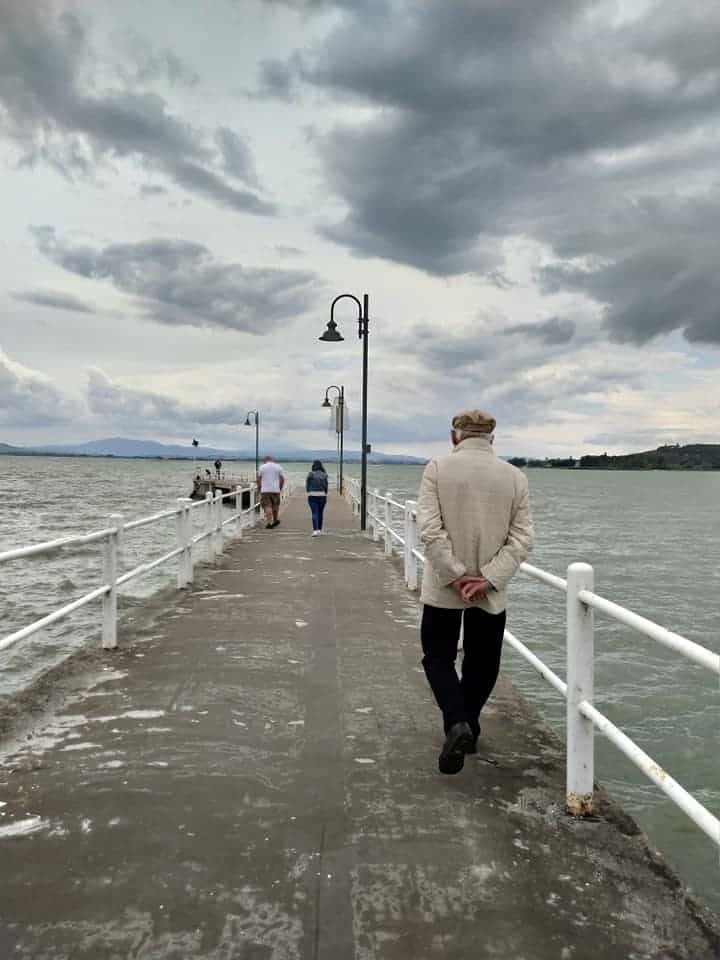Elderly man walking on pier