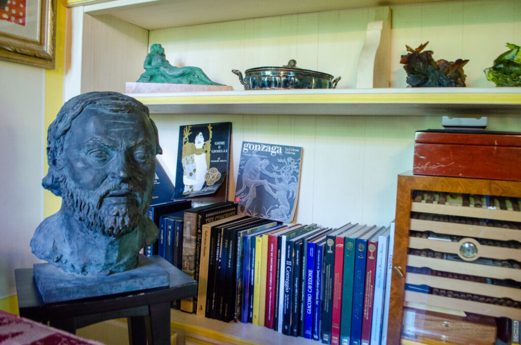 Bookcase with books and bust of Pavarotti