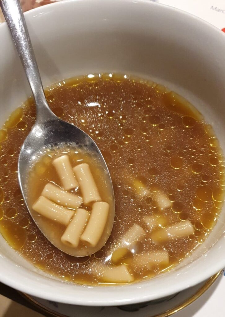 A bowl of pasta in beef stock